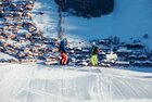 Zwei Skifahrer schauen von der Skipiste aus runter ins Dorf Alpbach