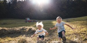 Zwei Kinder (ein Mädchen und ein Junge) springen im Heuhaufen hin und her  | © Alpbachtal Tourismus | Mathäus Gartner 