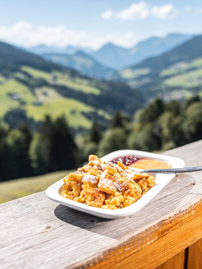 Im Vordergrund ein Kaiserschmarrn, im Hintergrund die schöne Aussicht auf das Alpbachtal  | © Alpbachtal Tourismus | shootandstyle 