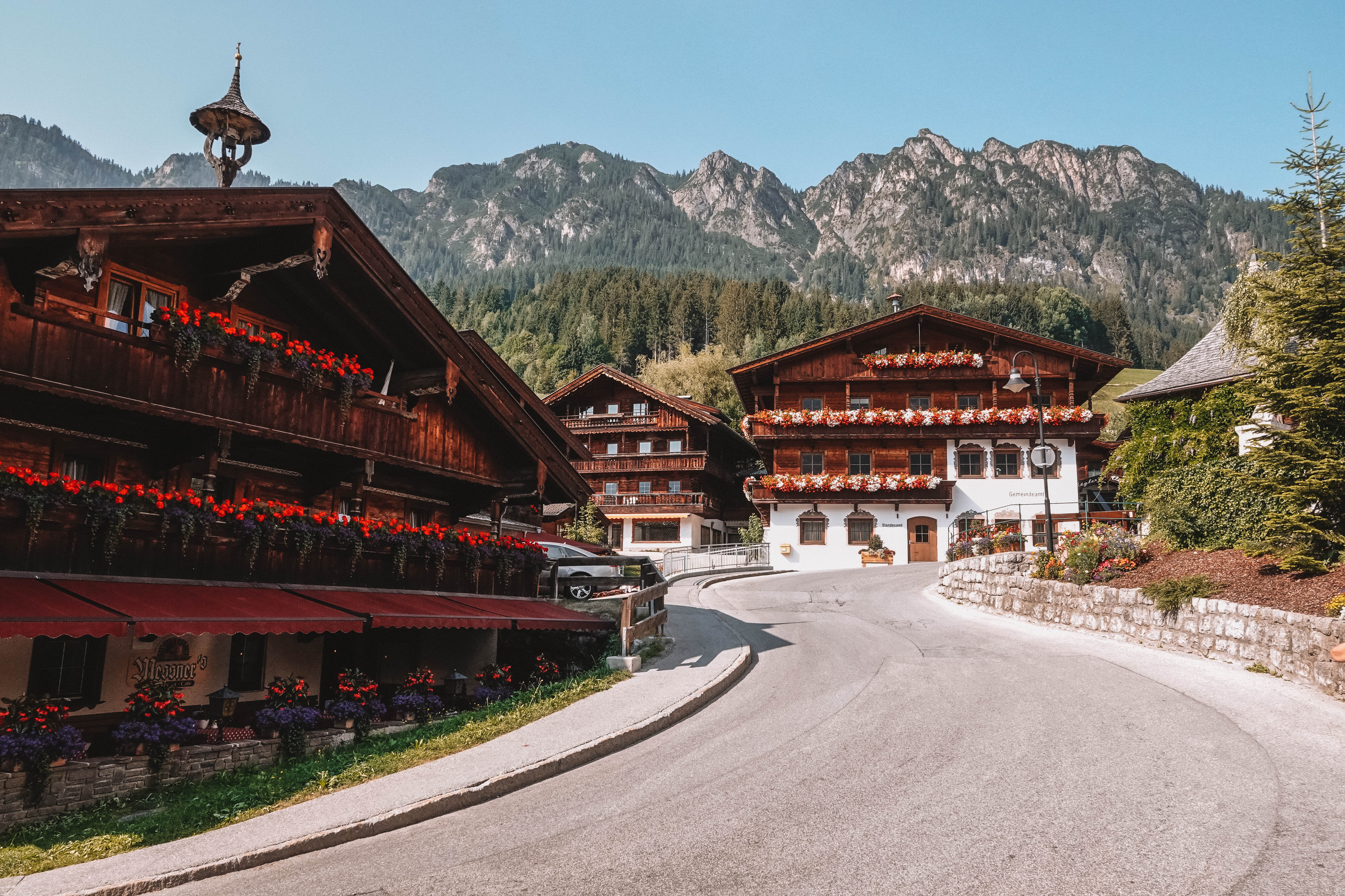 Häuser im Alpbachtaler Baustil, mit prachtvollen Blumen am Balkon, inmitten des Dorfzentrums in Alpbach | © Good Morning World | Janina Zasche 