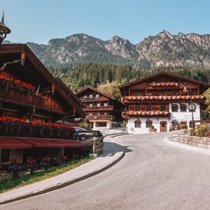 Häuser im Alpbachtaler Baustil, mit prachtvollen Blumen am Balkon, inmitten des Dorfzentrums in Alpbach | © Good Morning World | Janina Zasche 