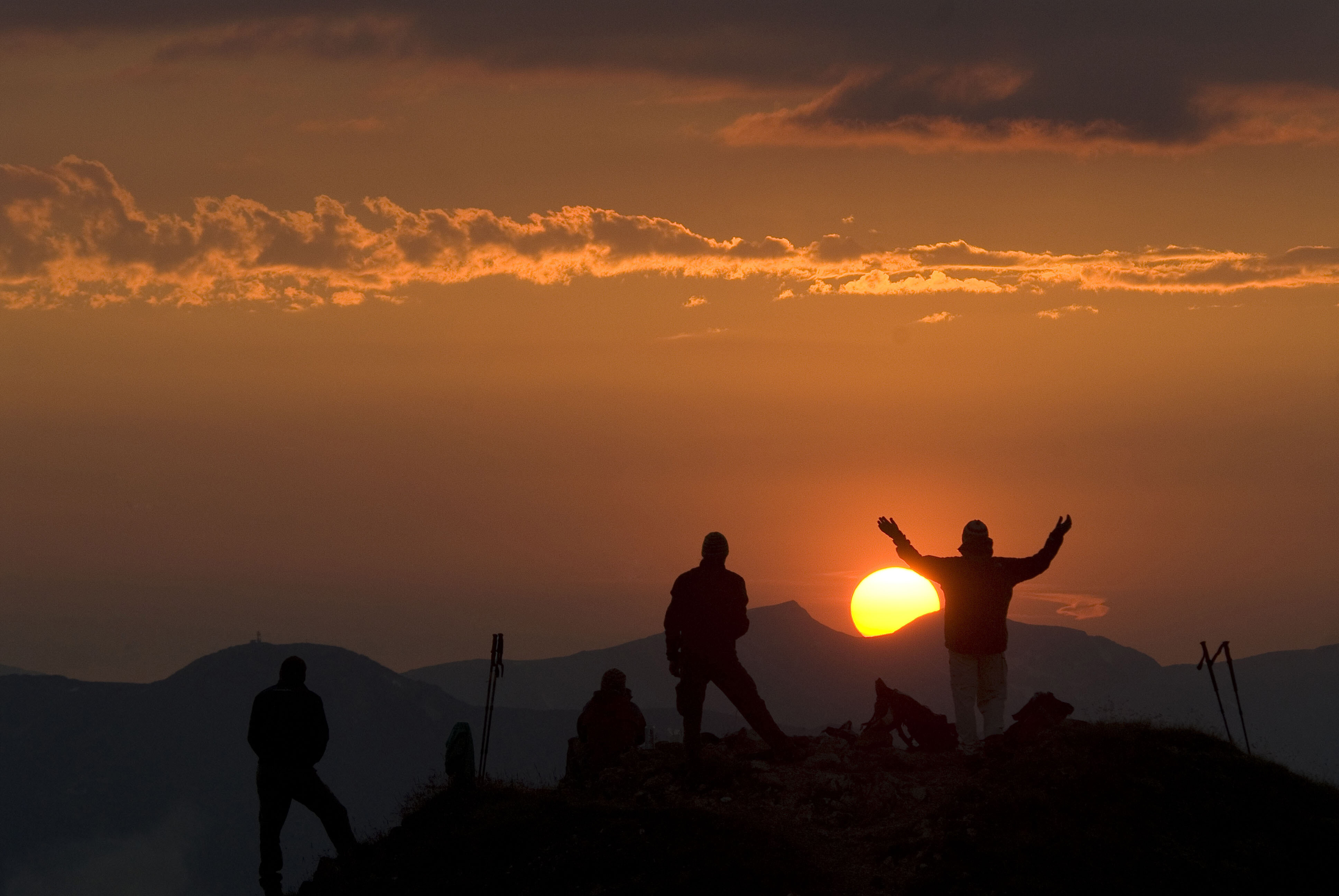 Auf diesem Bild zu sehen ist eine Gruppe von vier Personen, welche den Sonnenaufgang auf der Gratlspitze genießen | © Alpbachtal Tourismus | Bernhard Berger 